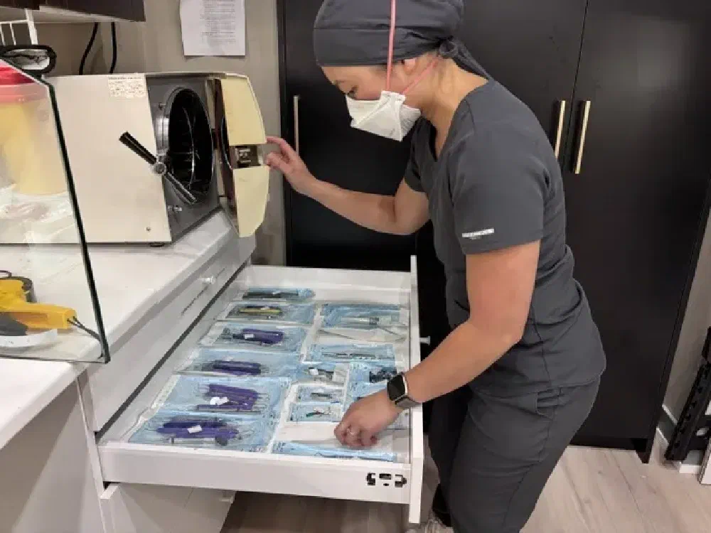 Dental team member organizing sealed sterile instrument packs