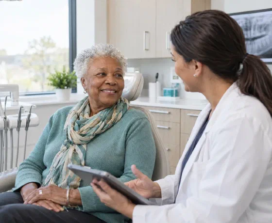 An older woman discussing her dental care with a clinician