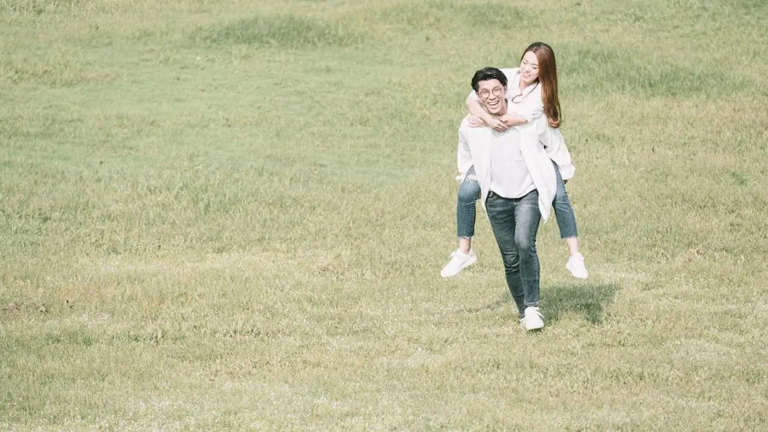 Joyful couple in a green meadow, portraying happiness and romance, related to affordable dental veneers Cookstown.