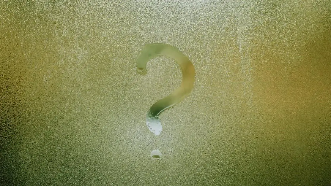 Question mark on foggy glass symbolizing mysterious causes of toothache without cavities.