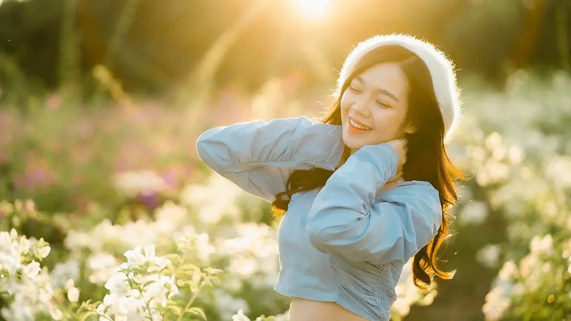 Woman smiling in flower garden at sunrise, highlighting Cookstown cosmetic smile makeover packages.