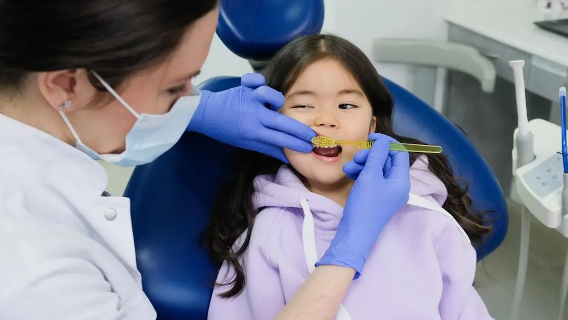 Emergency pediatric dentist in Cookstown treating young girl in modern clinic.