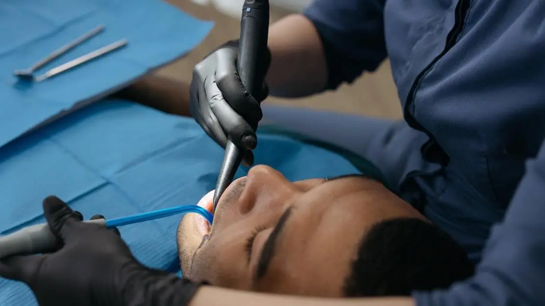 Dentist applying fissure sealants to a patient's tooth in a dental clinic