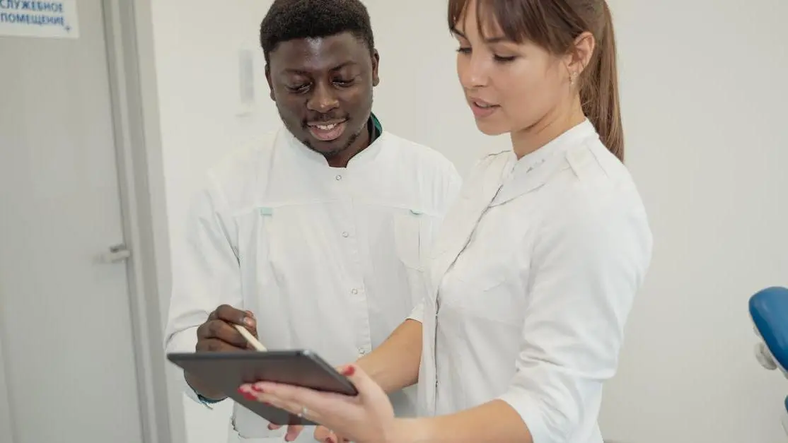 Medi dental professionals reviewing patient data on a tablet in a modern dental clinic