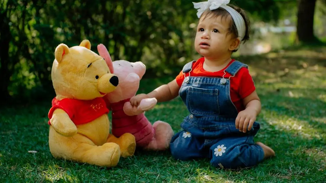 Child playing with Pooh Bear plush, relating to when children should get orthodontic evaluations.